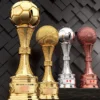 Three distinct trophies on display, including a prominent football trophy among them.