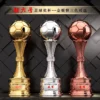 Three distinct soccer trophies displayed on a black background, showcasing various designs and styles.
