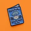 Light blue enamel pin with "Passport Scotland Alba" text and a thistle design on an orange background.