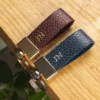 Litchi grain brown and blue leather keychain with gold colored metal head and key ring