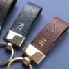 Litchi grain brown and blue leather keychain with gold colored metal head and key ring