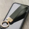 Dark Green Gold Plating Leather Keychain on a phone