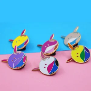 A collection of vibrant enamel pins featuring various designs, prominently showcasing a cute bunny face among them.