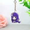 Un llavero acrílico de Genshin Impact con una chica de pelo morado que sujeta otro llavero.