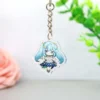 Un llavero acrílico con un popular personaje de anime de Genshin Impact, que luce colores vibrantes y un intrincado diseño.