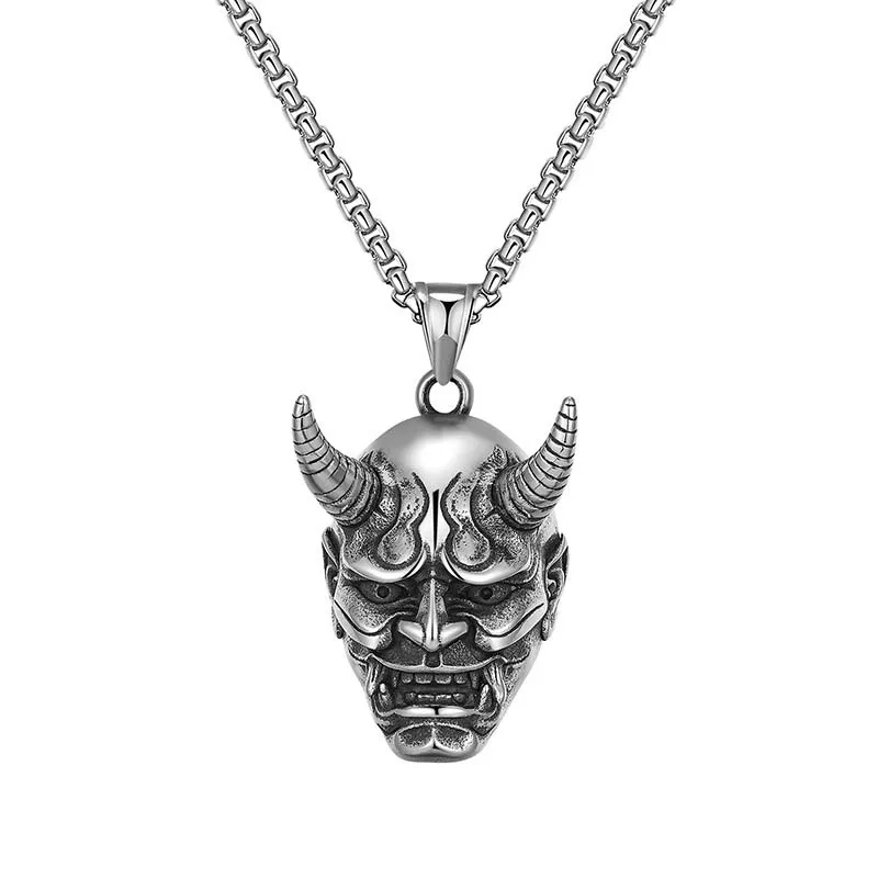 Colgante de plata con cabeza de demonio en una cadena, con un diseño de máscara de fantasma, que muestra intrincados detalles y un aspecto llamativo.