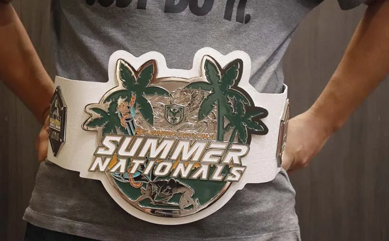 A man showcases a belt featuring the words "Summer Nationals" prominently displayed on the front.