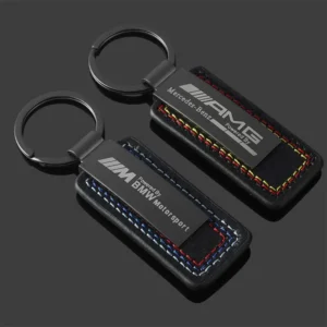 Two black key chains featuring the Mercedes AMG logo, elegantly displayed against a neutral background.