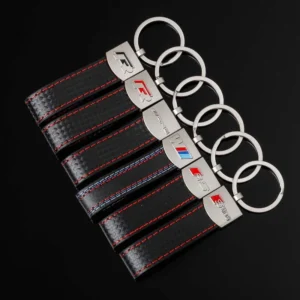 A display of four distinct key chains featuring the BMW logo, showcasing various designs and styles.