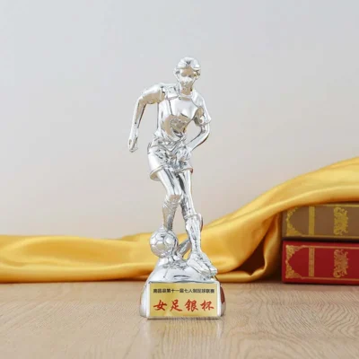 A silver trophy featuring a detailed soccer player figure atop its gleaming surface, symbolizing athletic achievement.