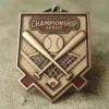 Gros plan sur une médaille en forme de balle de baseball et de batte, sur fond de tissu doux, mettant en valeur son design complexe.