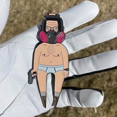 Divot tool shaped like a man with a gun in a hand.