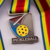 A medal featuring a pickleball design, symbolizing achievement in the sport of pickleball.