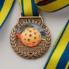 A medal featuring a tennis ball design, symbolizing achievement in pickleball sports.