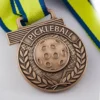 A medal featuring a pickleball design, symbolizing achievement in the sport of pickleball.