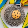 A medal featuring a pickleball design, symbolizing achievement in the sport of pickleball.