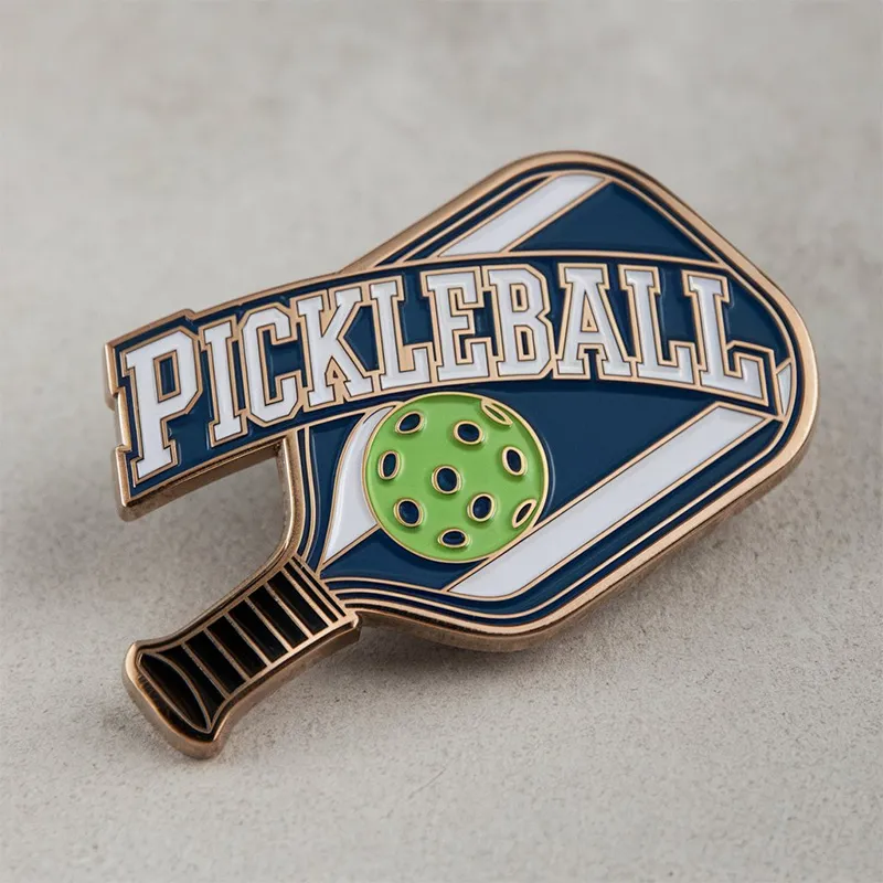 A pickleball pin featuring the word "pickleball" prominently displayed on its surface.