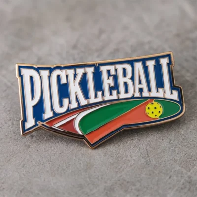 A pickleball pin featuring the word "pickleball" prominently displayed on its surface.