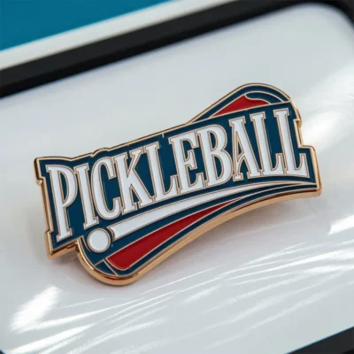 A pickleball pin featuring the word "pickleball" prominently displayed on its surface.