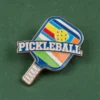 Un pin de pickleball con la palabra "pickleball" bien visible en su superficie.