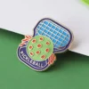 Un pin de pickleball con la palabra "pickleball" bien visible en su superficie.