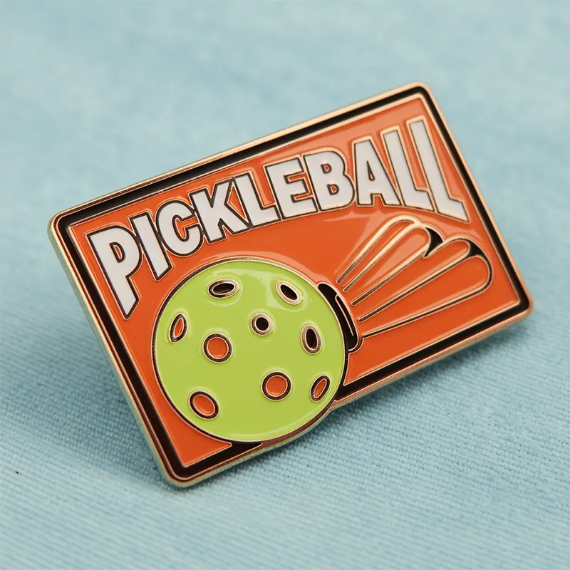 A pickleball pin featuring the word "pickleball" prominently displayed on its surface.