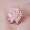 A pink ribbon pin with a heart, signifying love and support for important health and social causes.