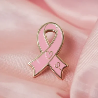 A pink ribbon pin with a heart, signifying love and support for important health and social causes.