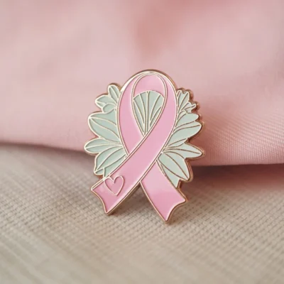 A pink ribbon pin with a heart, signifying love and support for important health and social causes.