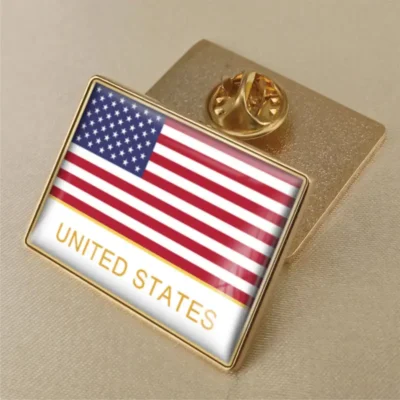 A gold pin featuring the United States flag, symbolizing patriotism and national pride.