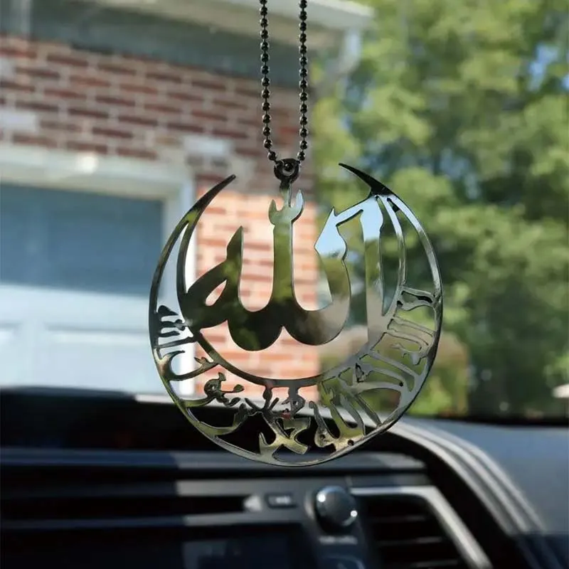 A close-up of a car window featuring a metal ornament displaying the word "Allah" as a decorative pendant.