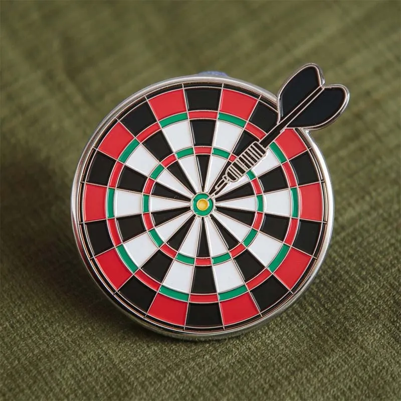 A badge showcasing a pin with a dart at its center, representing a darts theme.