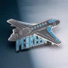An airplane-shaped pin displaying the word "peaken" prominently.