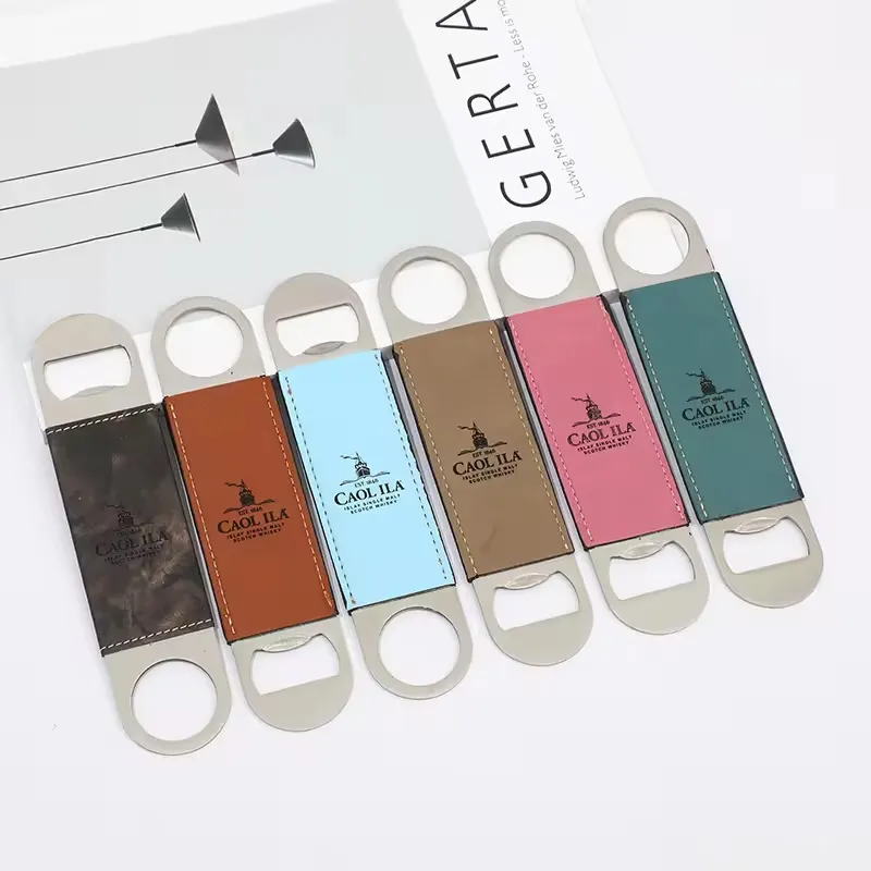 Six stainless steel bottle openers with leather handles in various colors (dark brown, light brown, light blue, tan, pink, and green) displayed on a white surface with part of a Gerta magazine in the background. Keywords: bottle opener.