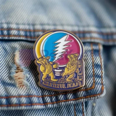 Individuelle Anstecknadel von Grateful Dead mit einem Bären und einem Blitzdesign, lebendig und auffällig.