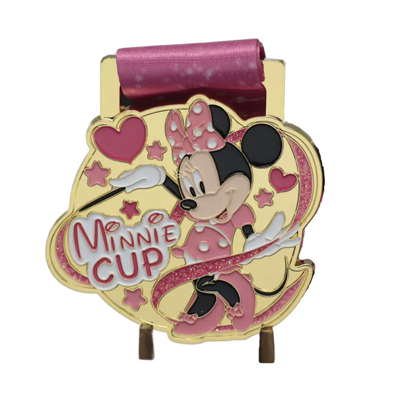 A colorful medal featuring Minnie Mouse with a pink ribbon and the text 'Minnie Cup,' displayed on a white background. Keywords: medal.