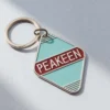 Llavero de hotel personalizado con la palabra "peakeen" en un elegante diseño, perfecto tanto para huéspedes como para coleccionistas.