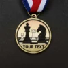Gold chess medal featuring intricate print and engraved text, symbolizing achievement in chess competitions.