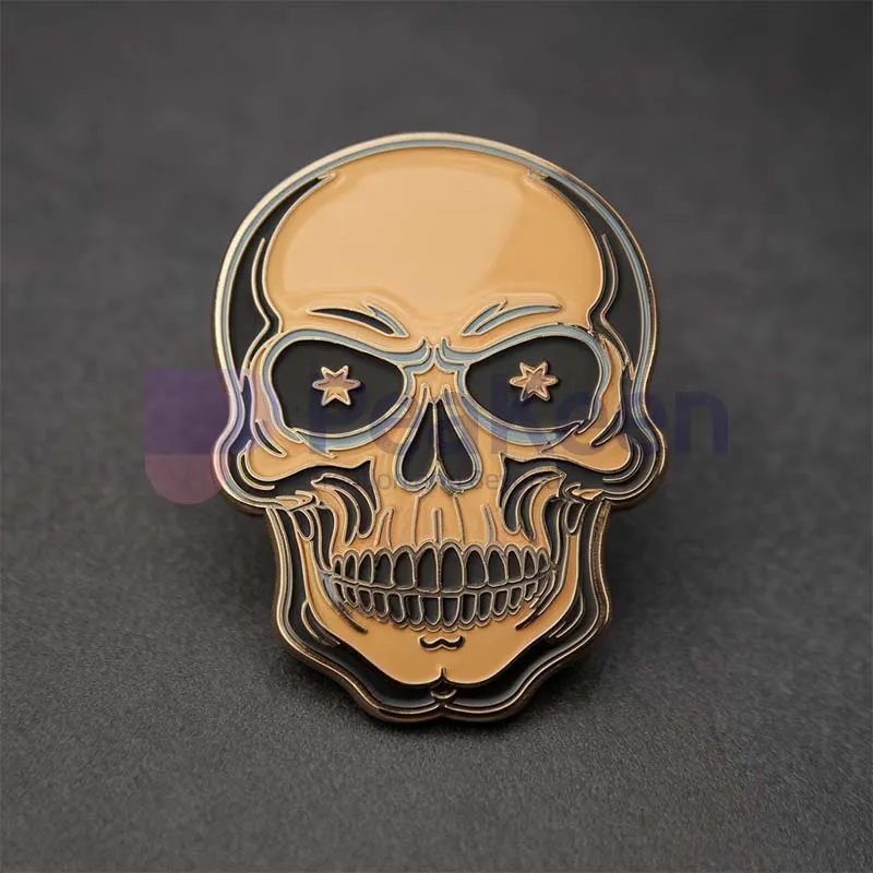 Custom gold skull pin featuring black eyes, showcasing a unique and stylish accessory for any outfit.