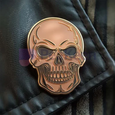 Individuelle goldene Totenkopf-Anstecknadel mit schwarzen Augen, die ein einzigartiges und stilvolles Accessoire für jedes Outfit darstellt.