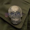 Spilla personalizzata con teschio d'oro e occhi neri, che rappresenta un accessorio unico ed elegante per qualsiasi abbigliamento.