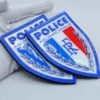 Une personne arbore fièrement un badge de police en TPU flexible personnalisé, mettant en valeur sa couleur argentée et sa forme distinctive.