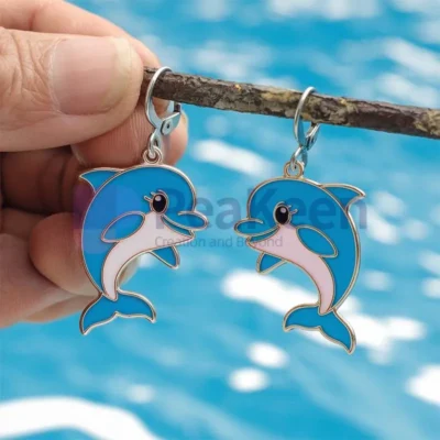 Custom soft enamel dolphin earrings featuring vibrant blue and pink beads, perfect for ocean lovers and unique jewelry enthusiasts.