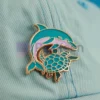 海洋生物と文学への愛を象徴する、開いた本の上に置かれたイルカのカスタムピン。