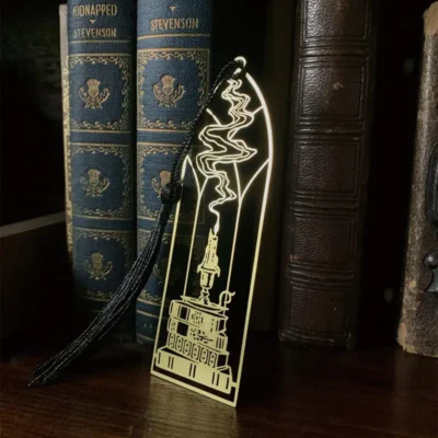 A book featuring a gold bookmark resting on its cover, highlighting custom Islamic bookmark designs.