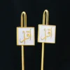 دبوسان مطليان بالذهب يتميزان بكتابات عربية معقدة، مصممان كعلامات إسلامية مخصصة.