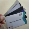 Una persona muestra cuatro fundas personalizadas con bloqueo RFID para tarjetas de crédito, exhibiendo sus características protectoras.