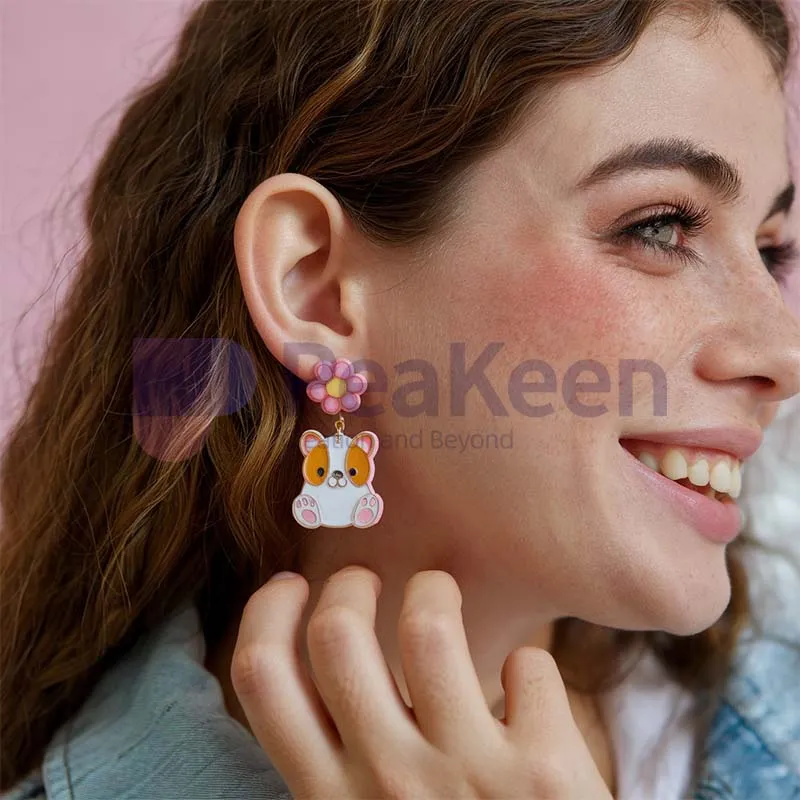 A person showcasing custom soft enamel earrings featuring a playful cat design.