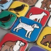 Una collezione di adesivi colorati per cani e gatti progettati come magneti da frigo personalizzati.