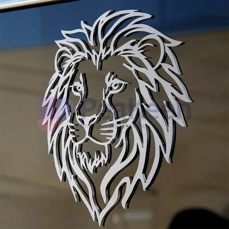 Autocollant métallique personnalisé en forme de tête de lion affiché sur la vitre d'une voiture, présentant un design féroce et élégant.